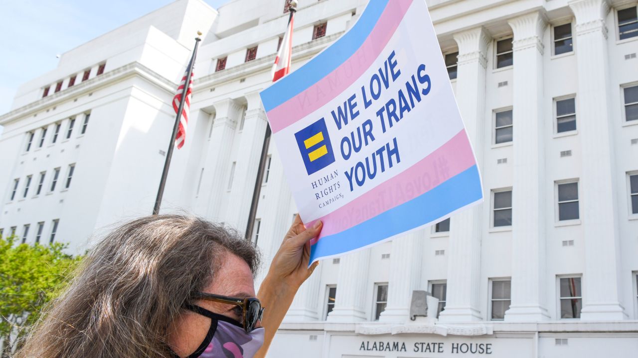 A woman holds a sign that reads "We Love Our Trans Youth" during a rally in Montgomery, Alabama, on March 30, 2021. 