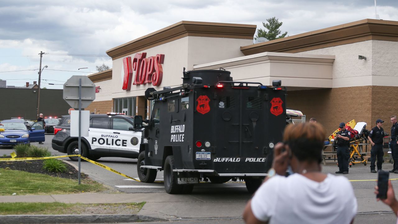 A crowd gathers as police investigate after a shooting at a supermarket on Saturday, May 14, 2022, in Buffalo, N.Y. Multiple people were shot  at the Tops Friendly Market.  Police have notified the public that the alleged shooter was in custody. (AP Photo/Joshua Bessex)