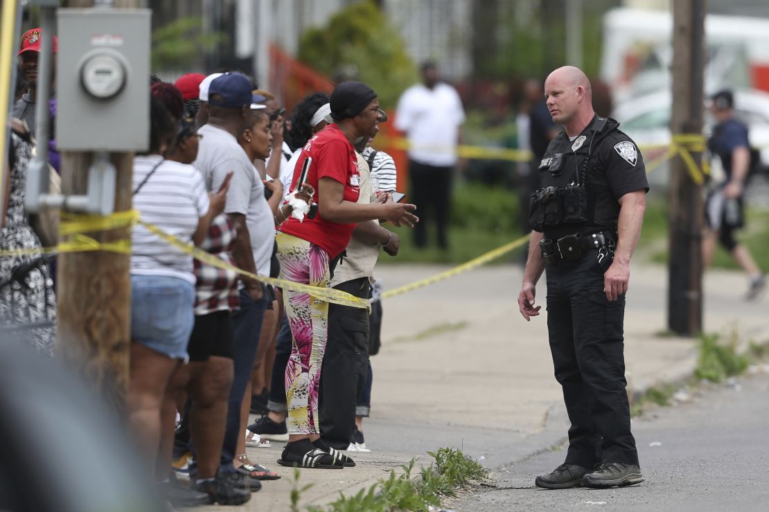 Police speak to bystanders after the shooting at a supermarket on May 14, 2022, in Buffalo, New York.