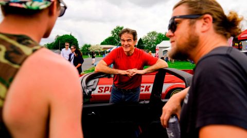 Republican Senate candidate Mehmet Oz, center, meets with attendees at a car show in Carlisle, Pennsylvania, on May 14, 2022. 