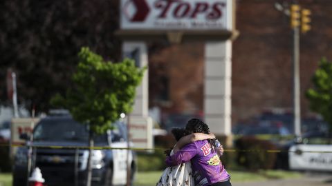 People hug outside the scene of a shooting at a supermarket in Buffalo on Saturday.