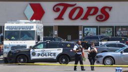 Police walk outside the Tops grocery store on Sunday, May 15, 2022, in Buffalo, N.Y. A white 18-year-old wearing military gear and livestreaming with a helmet camera opened fire with a rifle at the supermarket, killing and wounding people in what authorities described as "racially motivated violent extremism." (AP Photo/Joshua Bessex)