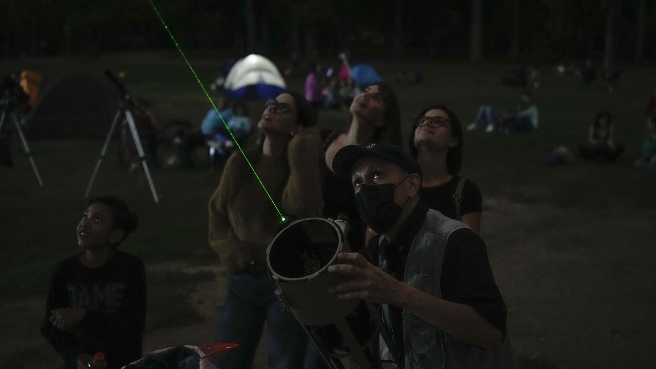 In Caracas, Venezuela, a man points a laser at the moon during the first blood moon of the year on Sunday.