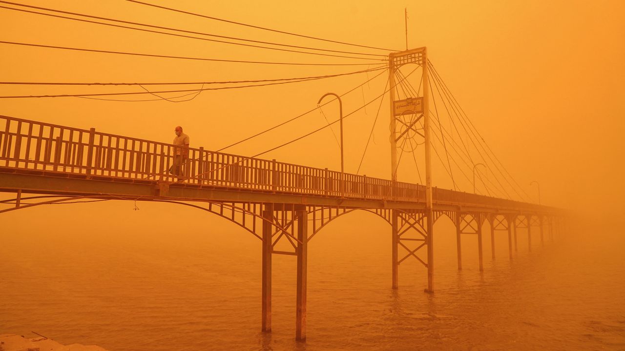 A man walks amidst a heavy dust storm along a pedestrian bridge over the Euphrates river in Nasiriyah, Iraq on May 16. Strong winds called Shamal that blow from the country's northwest commonly cause summertime dust storms in Iraq. A recent increase in storms has however turned skies orange and reduced air quality, hospitalizing some. The director of Iraq's meteorological office noted that drought is causing increased dust storms in Iraq, said NASA.