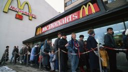 A queue of Soviets wait to enter a newly opened McDonald's on Gorky Street in Moscow in 1990. On the wall behind them is the McDonald's logo incorporated with the Soviet flag.   (Photo by Peter Turnley/Corbis/VCG via Getty Images)