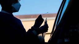 A medical personnel wearing personal protective equipment (PPE) is silhouetted while administering a swab test at a COVID-19 drive-thru testing site in San Pablo, California, U.S., on Tuesday, April 28, 2020. California, which has closed schools for the academic year, is considering bumping up the start of the new school year to late July or early August, Governor Gavin Newsom said. Photographer: