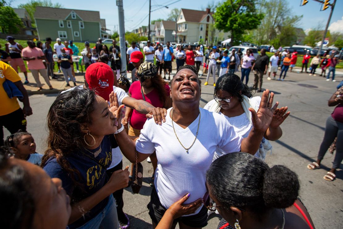 People surround Elea Daniel in prayer as she cries on Sunday. "God says we have to love no matter what," said Daniel, who was trying to find forgiveness for the man that targeted her community and left 10 dead.