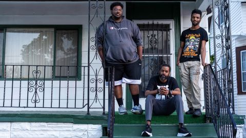 From left, Darious Morgan, Martin Bryant and Jordan Bryant stand on the steps of a family member's home, two doors down from Tops.