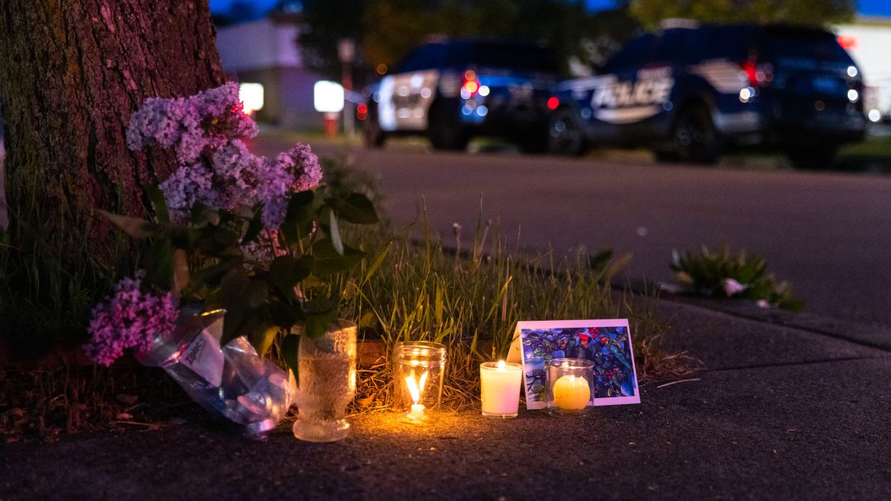 A small vigil is set up across the street from a Tops grocery store in Buffalo, New York, where a heavily armed 18-year-old White man shot 13 people, killing 10, on May 14.