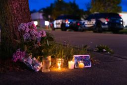 A small vigil is set up across the street from a Tops grocery store in Buffalo, New York, where a heavily armed 18-year-old White man shot 13 people, killing 10, on May 14.