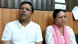 This image from video shows Sanjeev Ranjan Prasad, a 61-year-old retired government officer, and his wife Sadhana Prasad wait at a lawyer's chamber in Haridwar, India, Thursday, May 12, 2022. The Indian couple has sued their pilot son and daughter-in-law in a court demanding a grandchild within a year or compensation of 50 million rupees ($675,675). Prasad said this was an emotional and sensitive issue for him and his wife and they cannot wait any longer. His son got married six years ago. (KK Productions via AP)