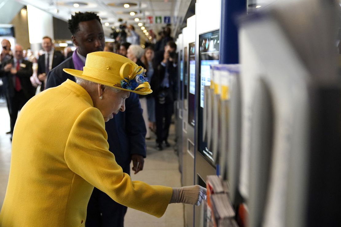 The Queen pictured using an Oyster card machine.
