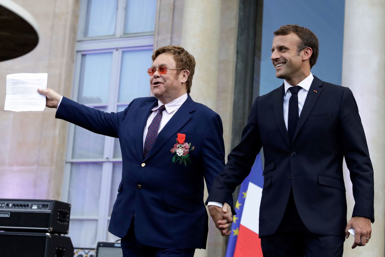 John and French President Emmanuel Macron arrive to speak to a crowd in Paris in June 2019. John was being honored with France's highest civilian award.