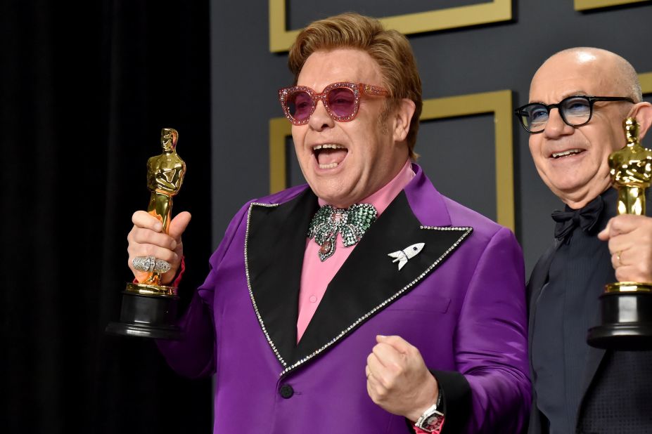 John and Taupin hold the Oscars they won for best original song in 2020. They won for 