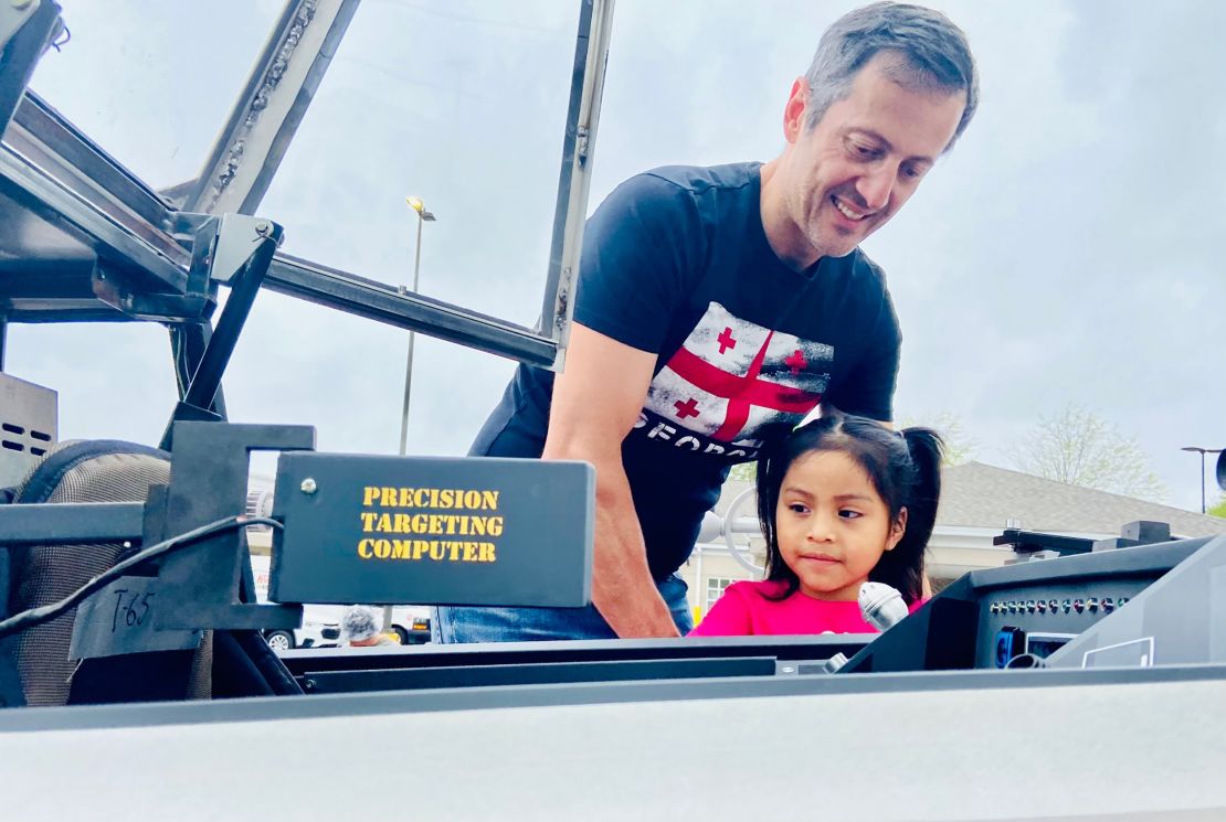 Lekiachvili helps a child check out the starfighter's features.