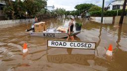 People use a boat to save items from their home at Torwood Street, Auchenflower on March 3, 2022 in Brisbane