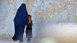 TOPSHOT - A burqa-clad woman walks with a girl along a street in Kabul on May 7, 2022. - The Taliban on May 7 imposed some of the harshest restrictions on Afghanistan's women since they seized power, ordering them to cover fully in public, ideally with the traditional burqa. (Photo by Ahmad SAHEL ARMAN / AFP) (Photo by AHMAD SAHEL ARMAN/AFP via Getty Images)