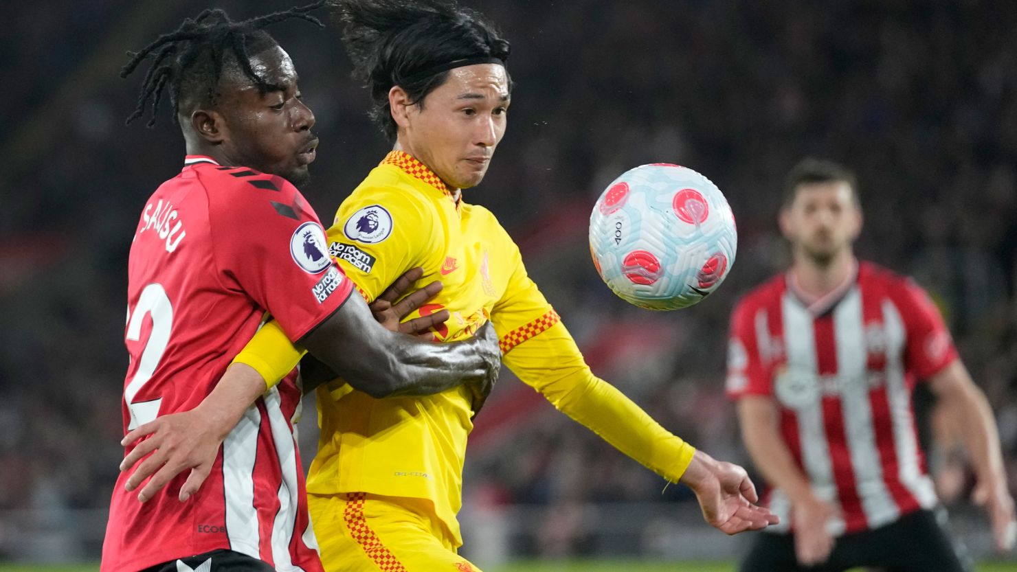 Southampton's Mohammed Salisu, left, challenges for the ball with Liverpool's Takumi Minamino.