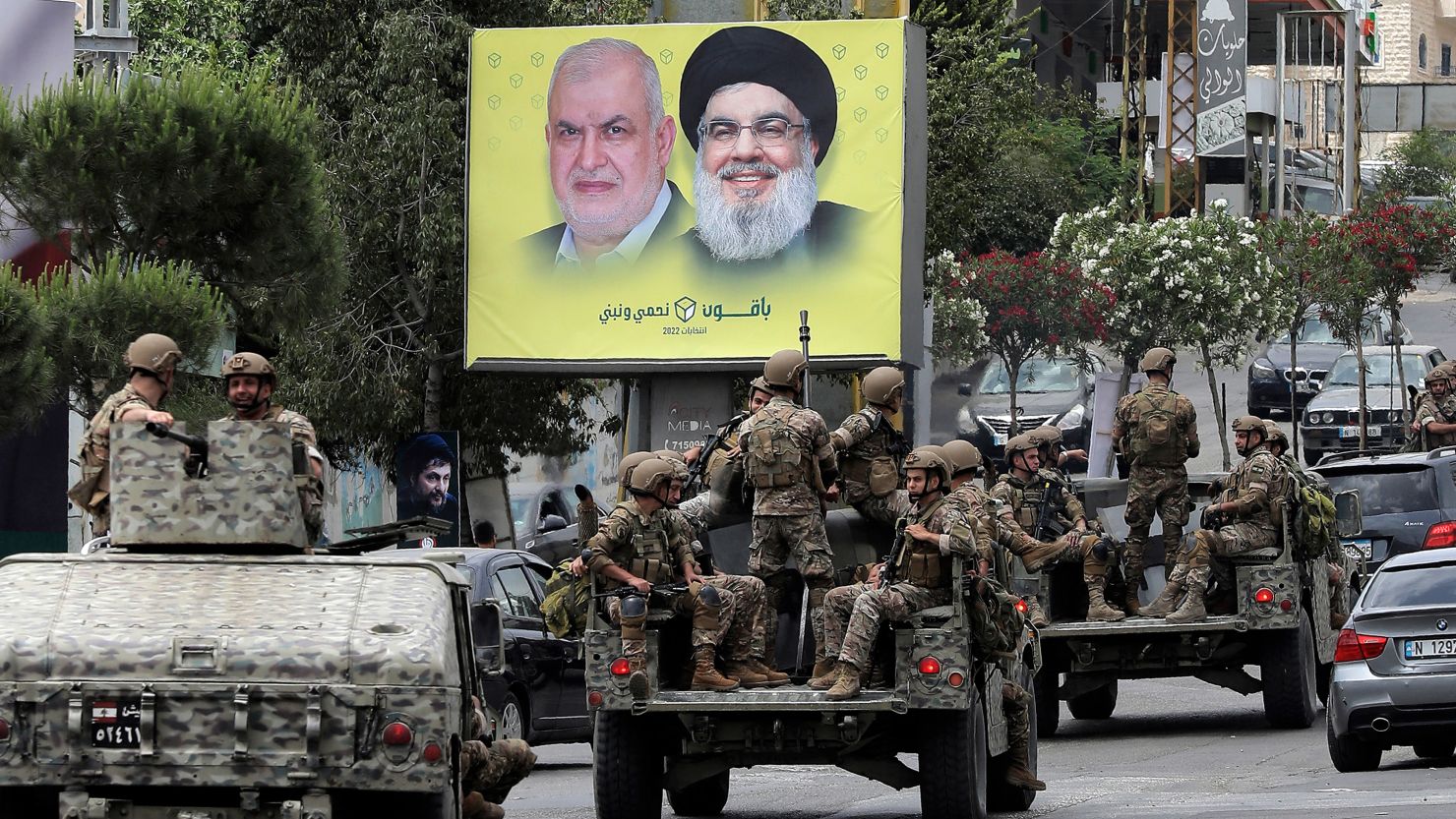 Lebanese army vehicles drive past a sign showing the images of the leader of Hezbollah Hassan Nasrallah and the movement's parliamentary candidate Mohammed Fneish, along a road in the city of Nabatiyeh, on May 15. 