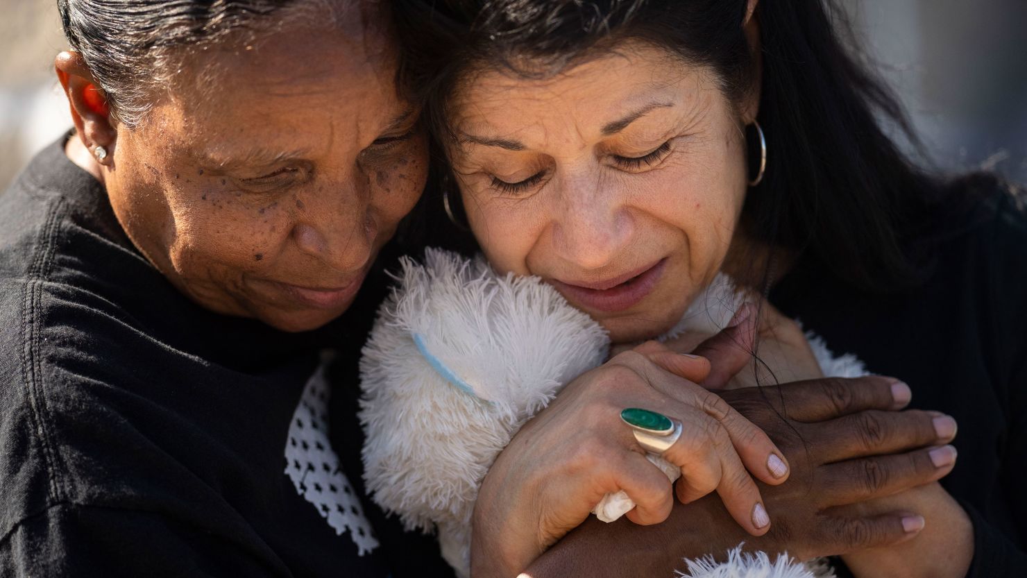 Jeanne LeGall hugs Claudia Carballada as she pays her respects at an makeshift memorial at the scene of a mass shooting at Tops Friendly Market in Buffalo, New York, on Sunday, May 15, 2022.