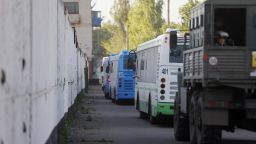 Buses with Ukrainian servicemen evacuated from the besieged Mariupol's Azovstal steel plant stand near a prison in Olyonivka, territory under the government of the Donetsk People's Republic, eastern Ukraine, Tuesday, May 17, 2022. More than 260 fighters, some severely wounded, were pulled from a steel plant on Monday that is the last redoubt of Ukrainian fighters in the city and transported to two towns controlled by separatists, officials on both sides said. (AP Photo/Alexei Alexandrov)