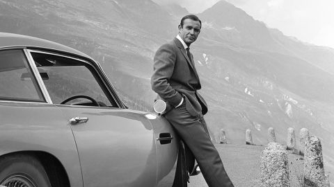 Actor Sean Connery poses as James Bond next to an Aston Martin DB5 in a scene from 'Goldfinger' in 1964.
