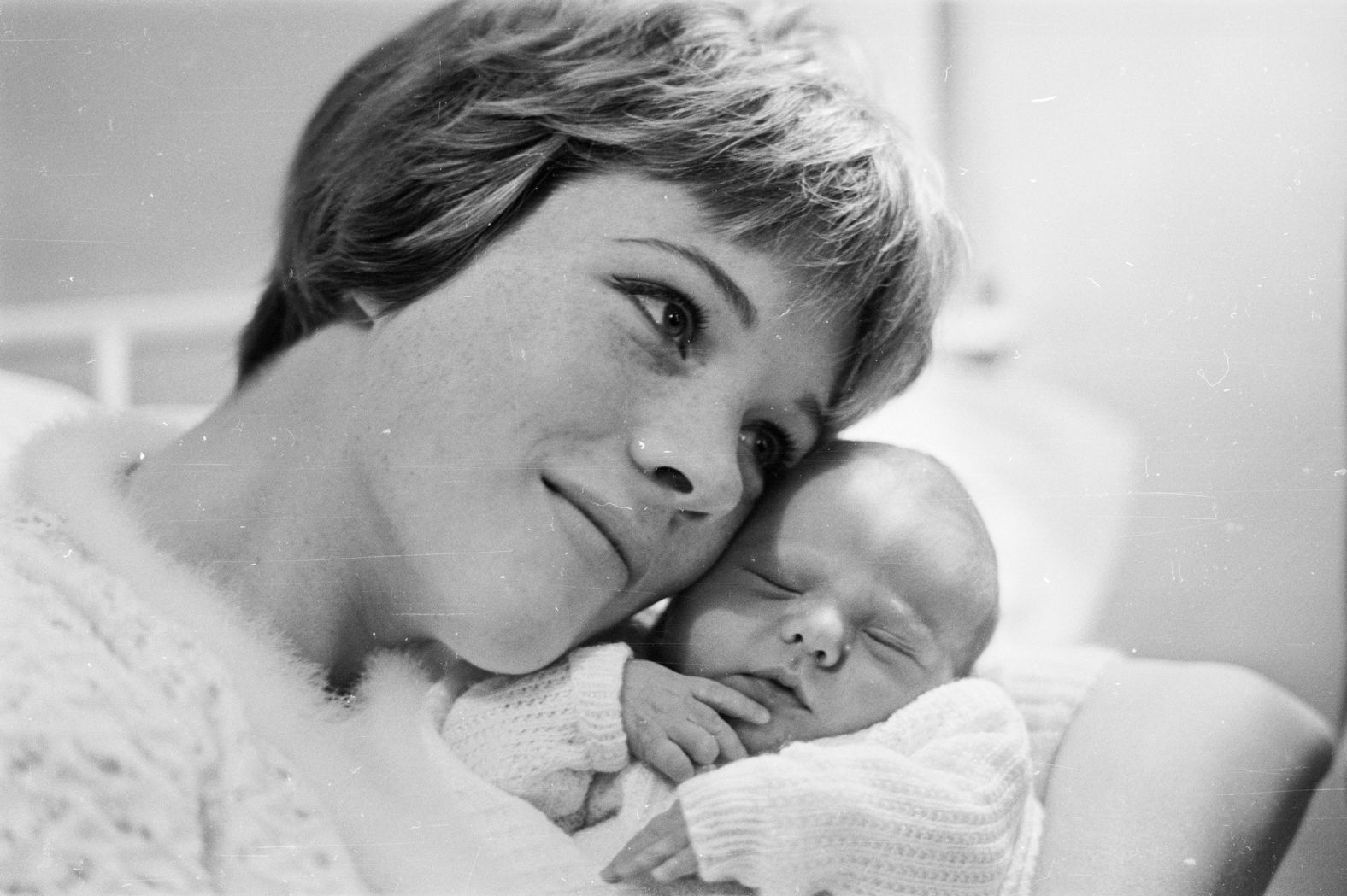 Andrews snuggles with her newborn daughter, Emma, in 1962.