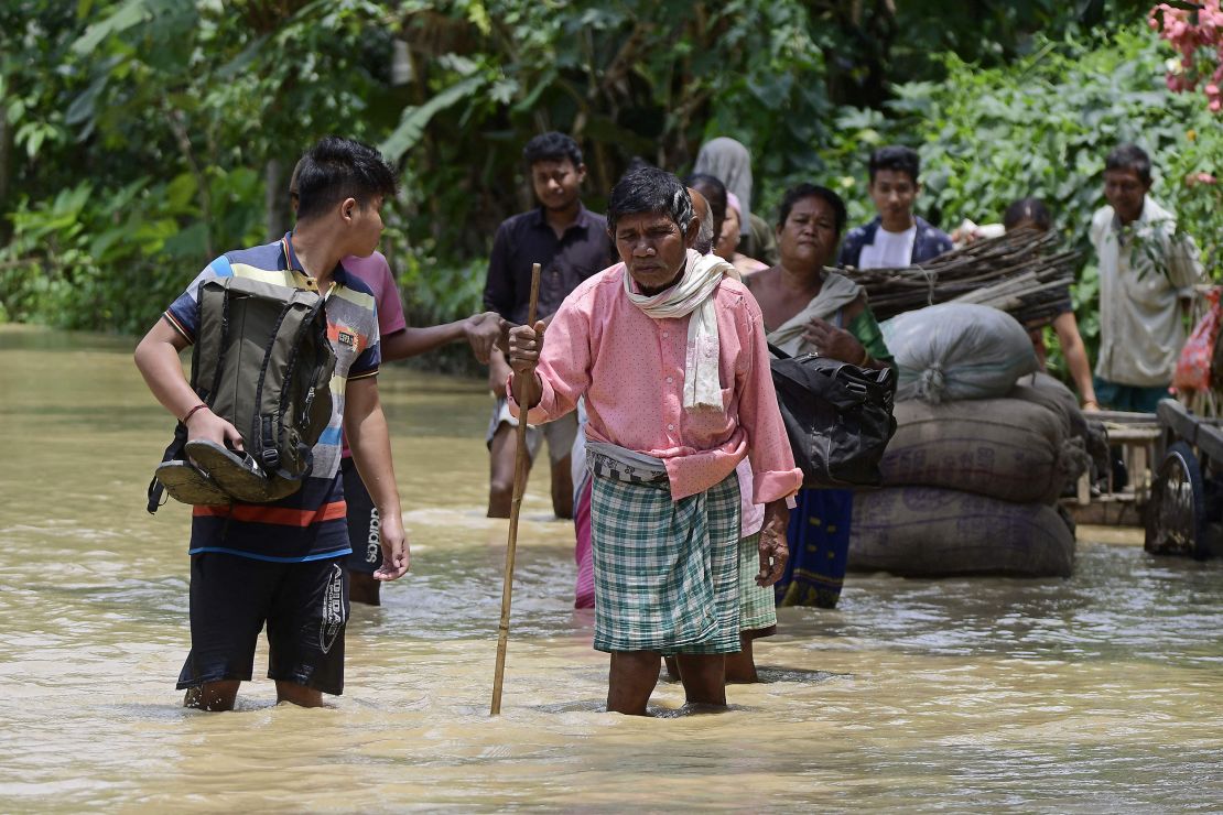 People wade through flood waters in Nagaon district of India's Assam state on May 18.