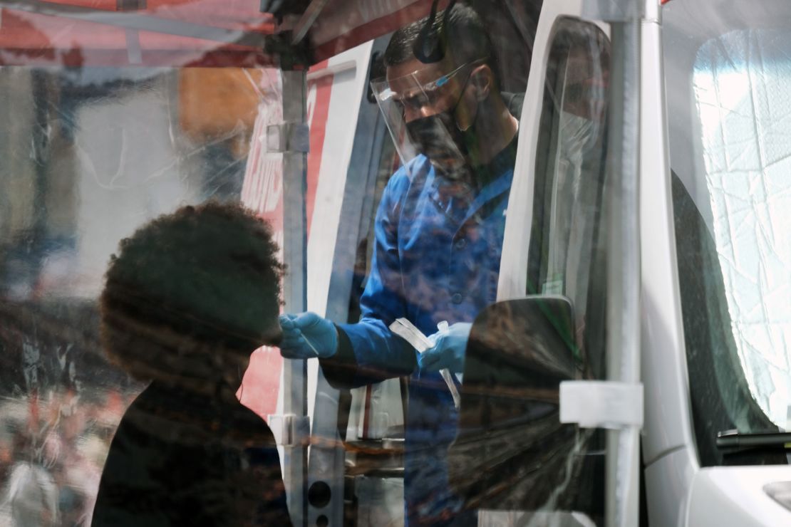 NEW YORK, NEW YORK - MAY 03: A person is tested at a Covid-19 testing van in Times Square on May 03, 2022 in New York City. Health officials announced on Monday that New York City will raise its COVID alert level to medium as cases have surpassed a rate of 200 per 100,000 people in the five boroughs.