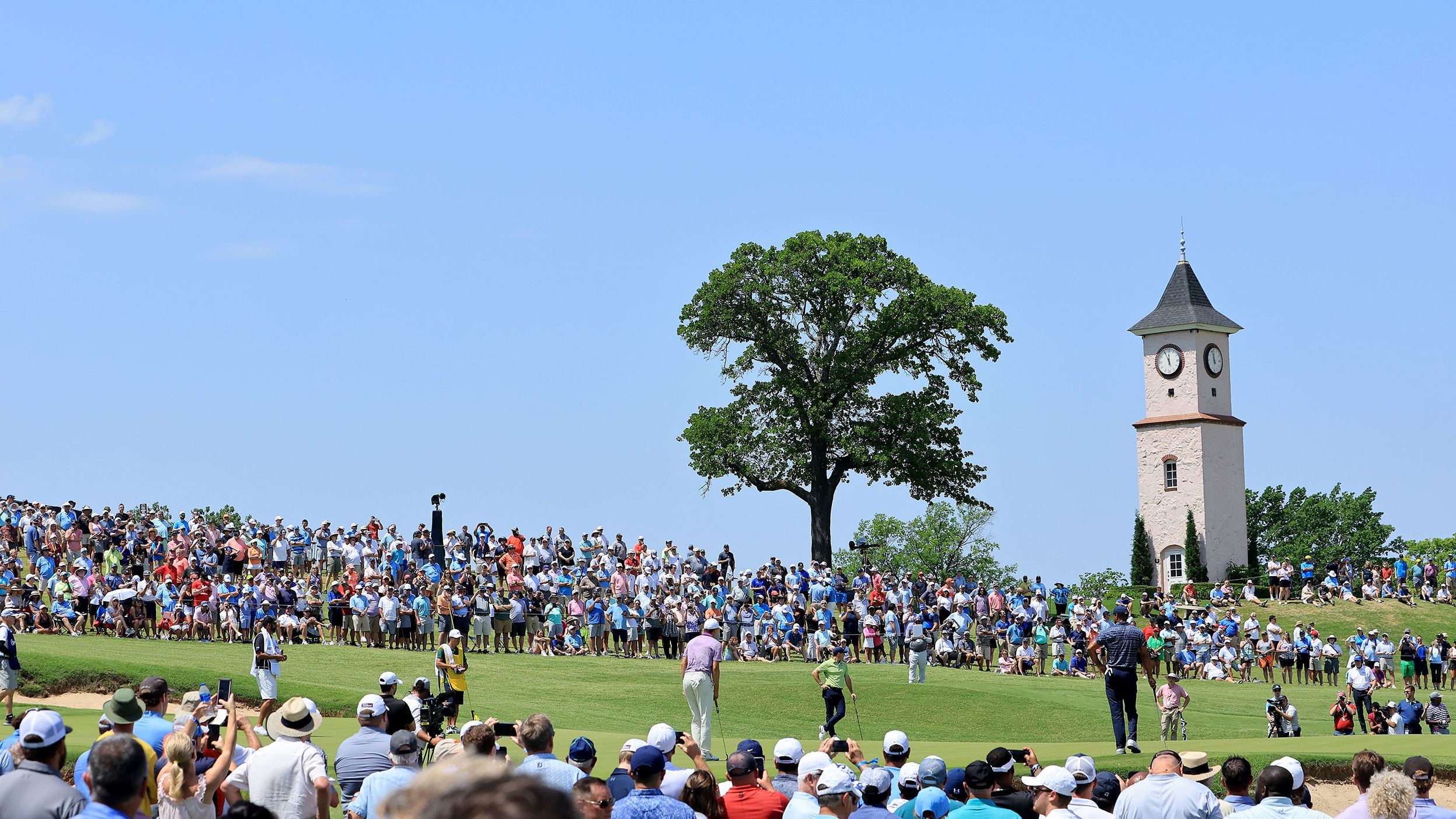 Jordan Spieth, Rory McIlroy and Tiger Woods stand on the fourth green.