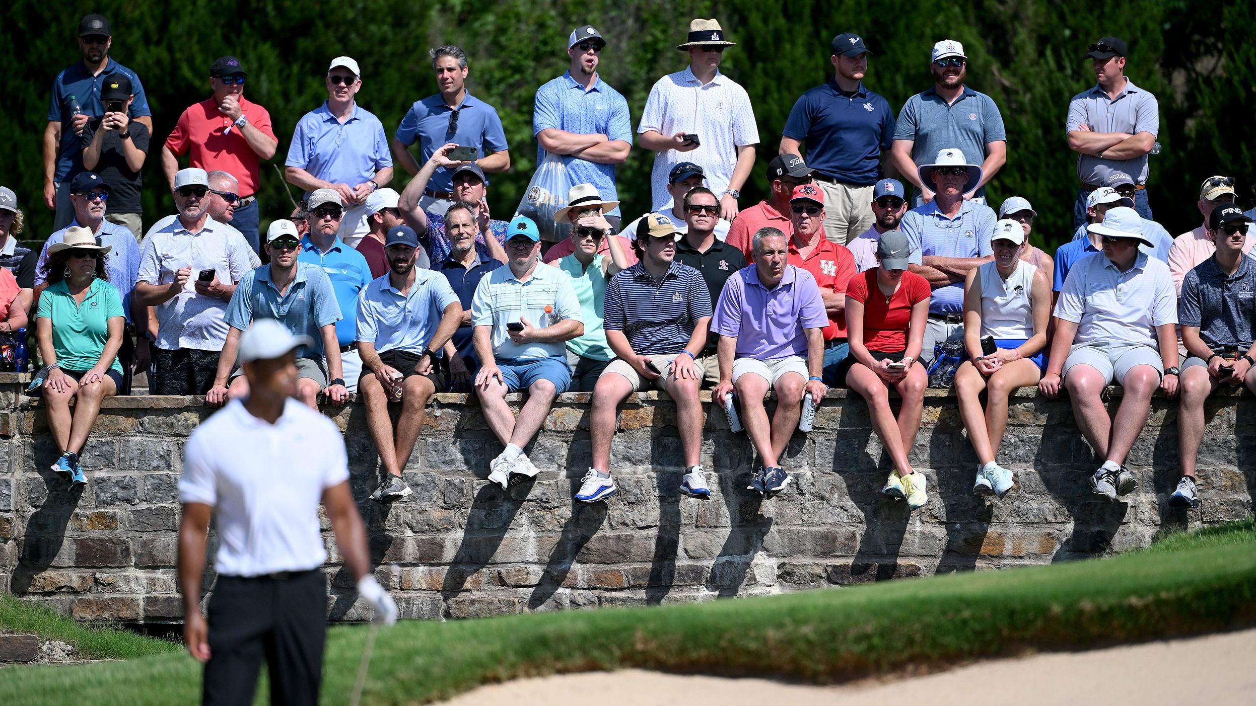 Fans watch as Tiger Woods prepares to play a shot on the sixth hole.