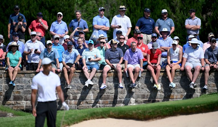 Fans watch as Tiger Woods prepares to play a shot on the sixth hole.
