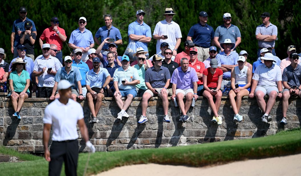 Fans watch as Tiger Woods prepares to play a shot on the sixth hole.