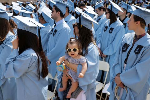 Graduate Julia Pontes holds her 8-month-old daughter, Stella Lyra, during the Columbia University commencement ceremony in New York on Wednesday, May 18.