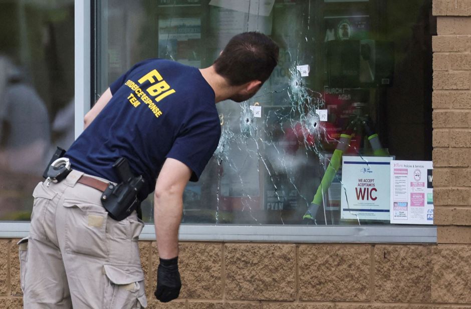 A member of the FBI looks at bullet holes at the scene of the shooting at <a href="https://www.cnn.com/2022/05/19/us/buffalo-supermarket-shooting-thursday/index.html" target="_blank">Tops supermarket</a> in Buffalo on Monday, May 16.
