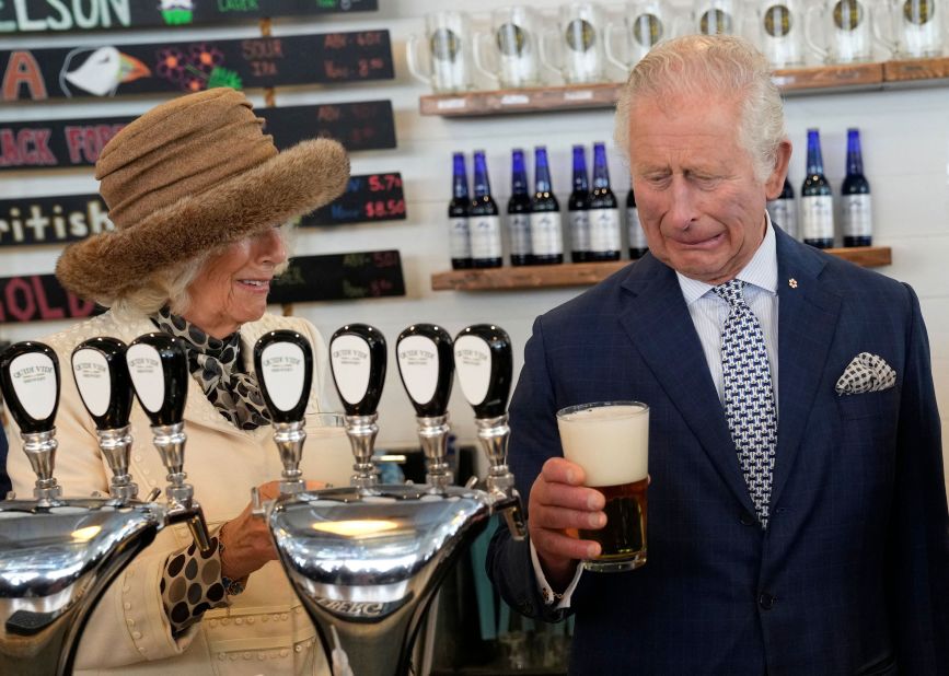Camilla looks on as Charles reacts to a bad pour of beer he made at a brewery in St. John's, Newfoundland and Labrador, in May 2022. They were on a three-day Canadian tour.