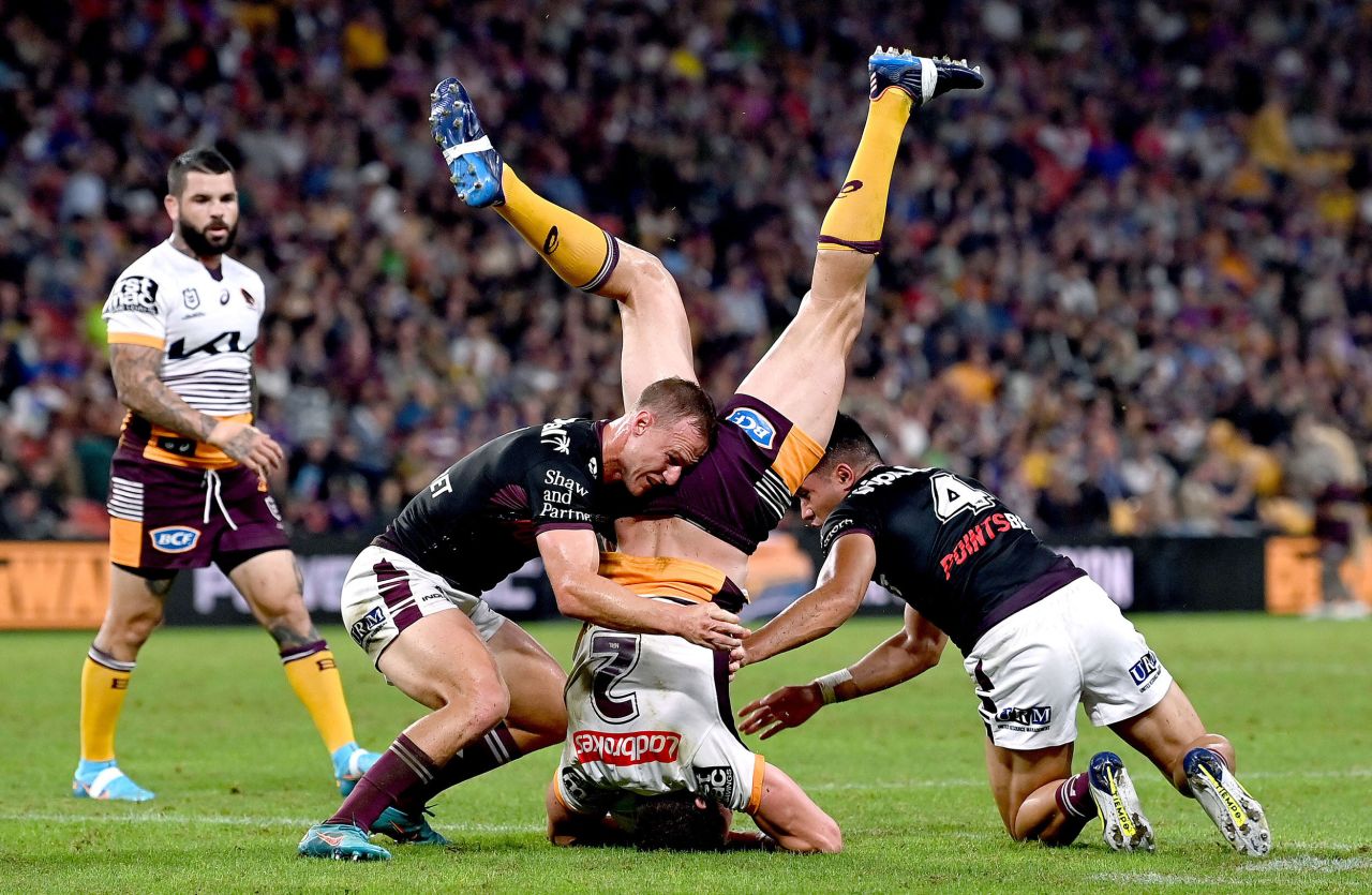 Brisbane Broncos' Corey Oates, center, is upended during a rugby match against Manly in Brisbane, Australia, on Friday, May 13.