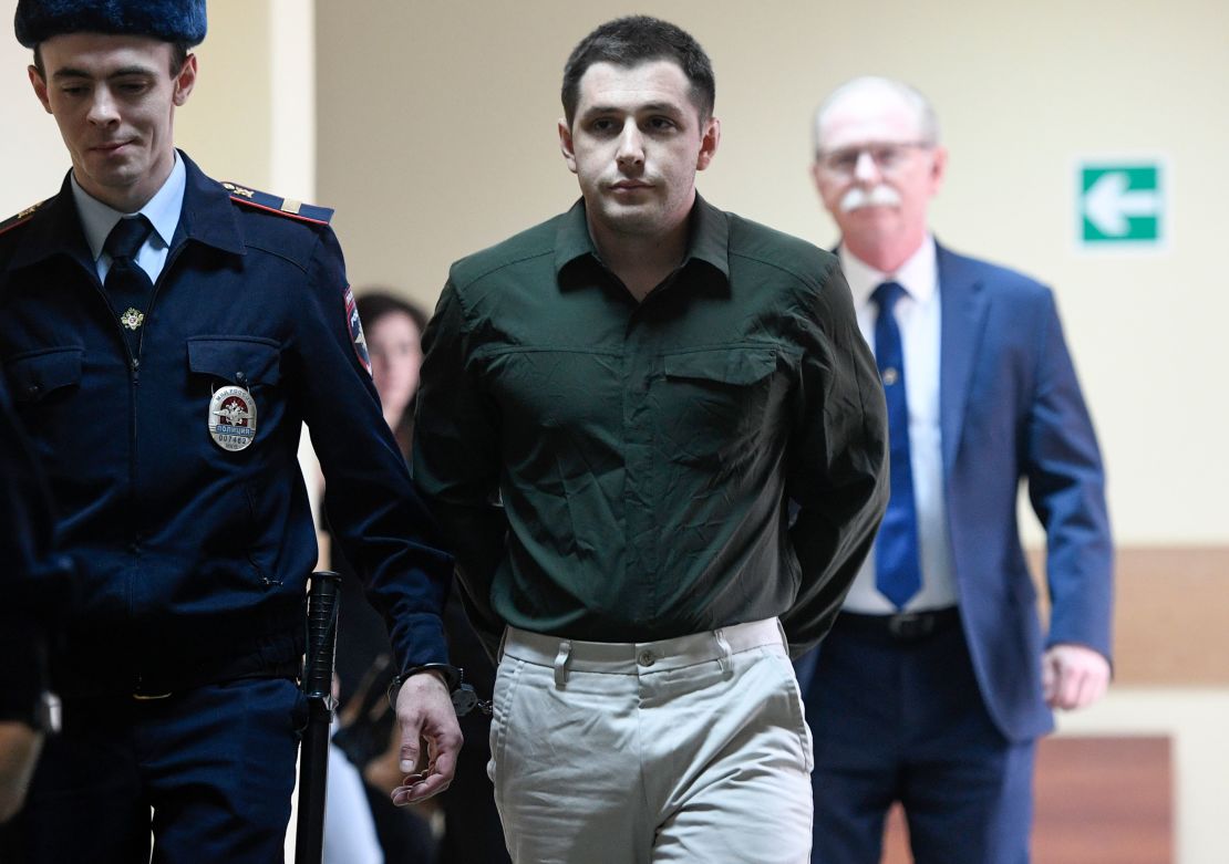 Police officers escort Trevor Reed, charged with attacking police, into a courtroom prior to a hearing in Moscow on March 11, 2020.