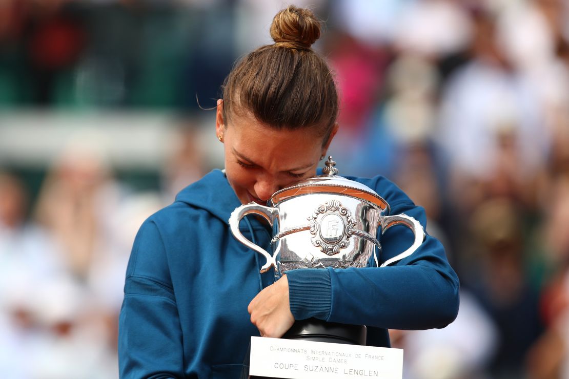 Simona Halep hugs the trophy as she celebrates victory following the ladies singles final against Sloane Stephens at the French Open final on June 9, 2018 in Paris, France.