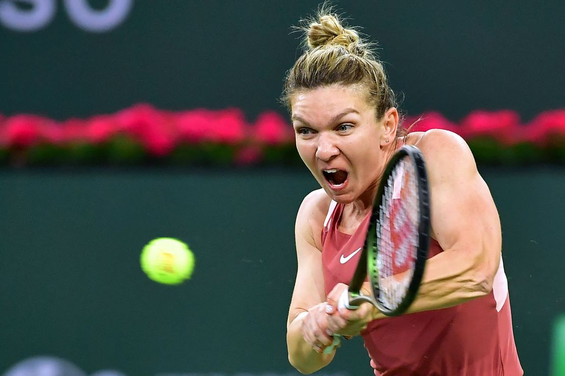Simona Halep hits a backhand return to Iga Swiatek of Poland in their WTA semifinal match at the Indian Wells tennis tournament on March 18, 2022.