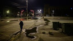 A pedestrian walks along a street past anti-tank obstacles shortly before a curfew in Dnipro on April 14, 2022, amid Russia's military invasion launched on Ukraine. 