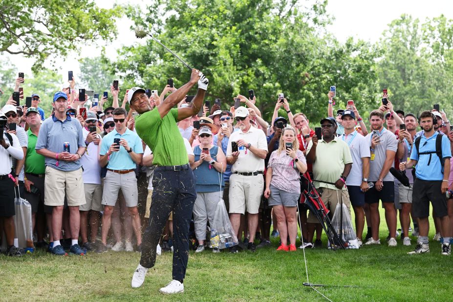Tiger Woods plays his second shot on the first hole as a gallery of fans look on during the second round.
