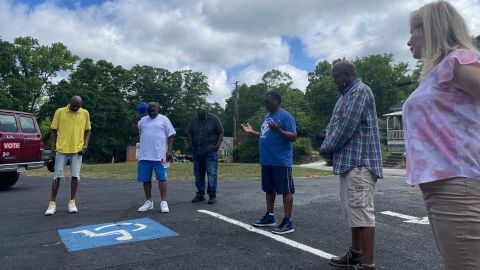 Faith and community leaders pause for a prayer in the parking lot of Breakthrough Deliverance Church before setting off for the polls on Saturday, May, 14, 2022, in Griffin, Georgia. 