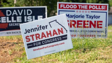 Campaign signs for Strahan, center, and Greene, right, are seen just outside of Rome in Silver Creek, Georgia, on May 12, 2022.