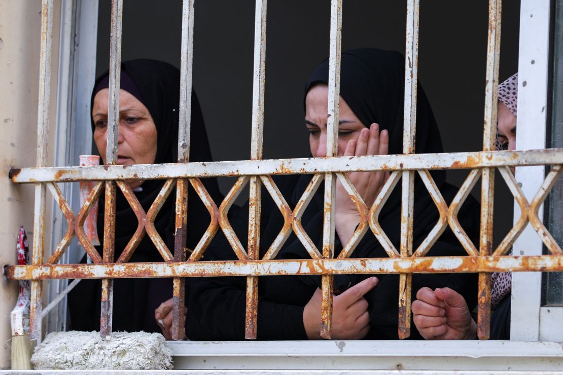 Mourners attend Amjad al-Fayed's funeral from a window in Jenin.