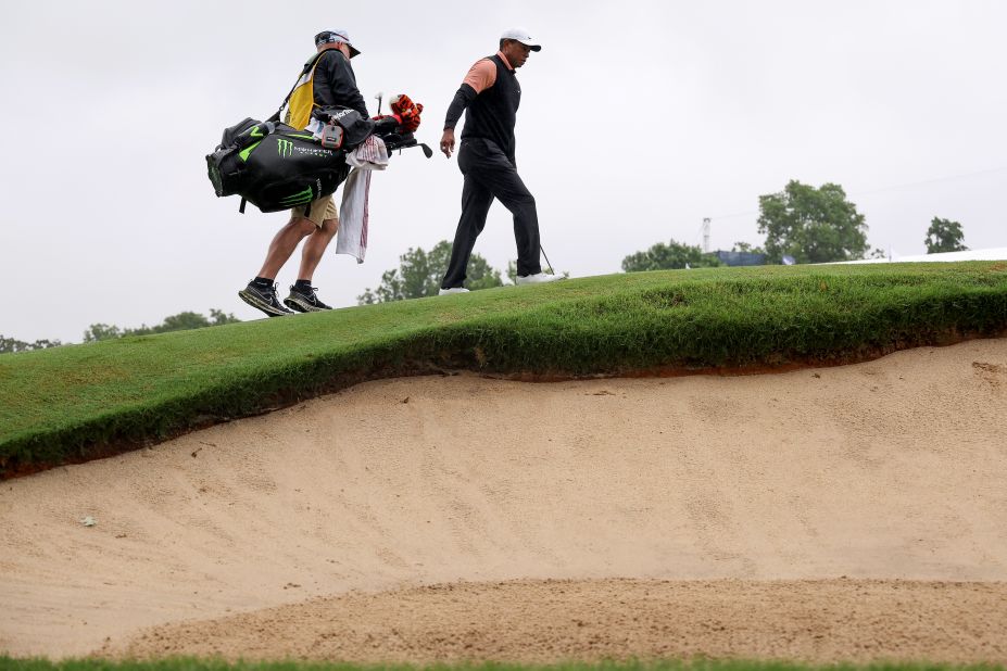 Tiger Woods and his caddy walk on the ninth green during the third round.