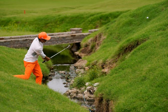 Rickie Fowler hits from the hazard on the 17th hole.