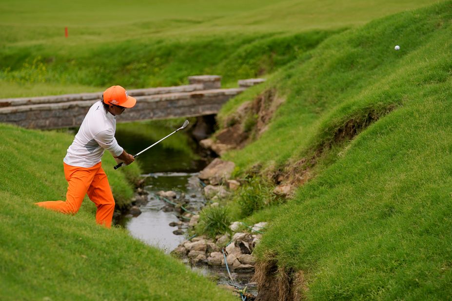 Rickie Fowler hits from the hazard on the 17th hole.