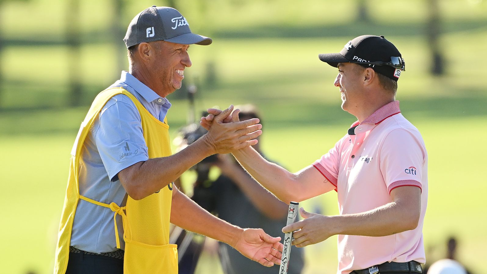 Justin Thomas reacts to his winning putt on the 18th hole with caddie Jim "Bones" Mackay.