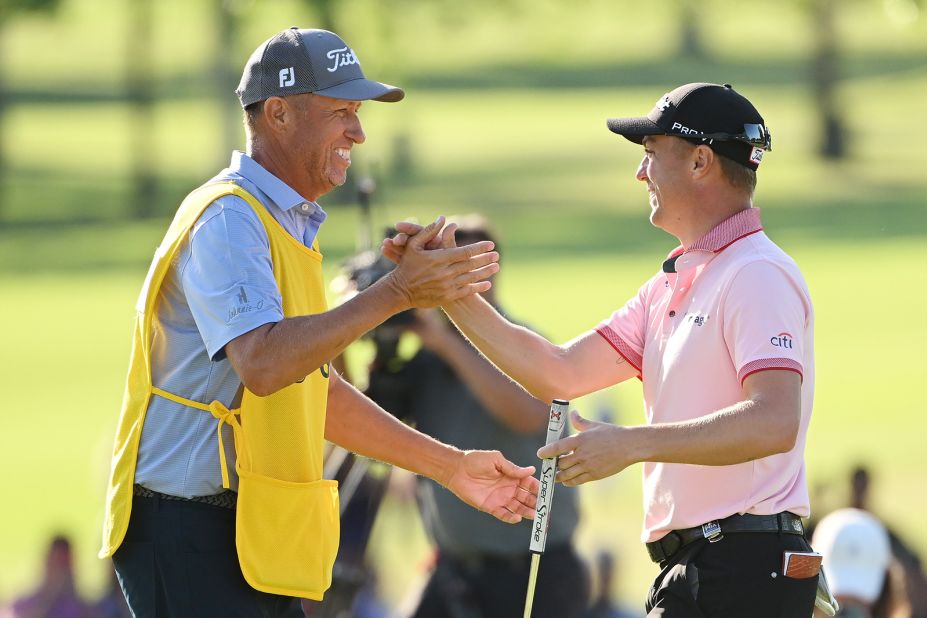 Justin Thomas reacts to his winning putt on the 18th hole with caddie Jim "Bones" Mackay.